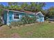 Turquoise home featuring a well-kept lawn and landscaped garden, showcasing the exterior details at 731 Cloverleaf Blvd, Deltona, FL 32725