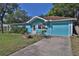 Turquoise home with manicured lawn, showcasing the home's architecture and curb appeal in a sunny setting at 731 Cloverleaf Blvd, Deltona, FL 32725