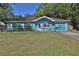 Charming turquoise home featuring a well-maintained lawn, mature trees, and a cozy, inviting front yard at 731 Cloverleaf Blvd, Deltona, FL 32725