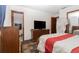 Main bedroom with a dresser, television, and doorway leading to a private bathroom at 731 Cloverleaf Blvd, Deltona, FL 32725