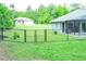 Backyard with black chain link fence and partial view of screened in lanai and neighboring home at 7407 Sw 202 Ct, Dunnellon, FL 34431