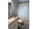 Cozy bathroom featuring a granite vanity, framed mirror, and a shower with stylish, striped curtain at 7407 Sw 202 Ct, Dunnellon, FL 34431