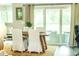 Bright dining area with a rustic table, white chairs, and sliding glass doors at 7407 Sw 202 Ct, Dunnellon, FL 34431