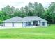 Charming single-story home with a three-car garage and well-manicured lawn, offering curb appeal and ample parking at 7407 Sw 202 Ct, Dunnellon, FL 34431