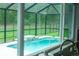 A screened-in pool features cool blue water and lush green landscaping around the fence at 7407 Sw 202 Ct, Dunnellon, FL 34431