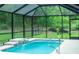 Screened pool with waterfall feature and verdant backyard view at 7407 Sw 202 Ct, Dunnellon, FL 34431