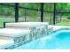 Close up of a waterfall feature cascading into the beautiful, private swimming pool at 7407 Sw 202 Ct, Dunnellon, FL 34431