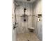 Walk-in shower with dual shower heads, a corner seat, and a shampoo niche at 7407 Sw 202 Ct, Dunnellon, FL 34431