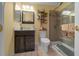 Cozy bathroom featuring a glass shower, a dark wood vanity, and decorative shelves at 7692 Sw 117Th Street Rd, Ocala, FL 34476