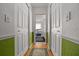 Hallway featuring neutral walls, wood flooring, with closet space and views into other rooms, creating a sense of flow at 7692 Sw 117Th Street Rd, Ocala, FL 34476