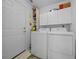 Functional laundry room features a full-sized washer and dryer, with white cabinetry for storage and a practical design at 7692 Sw 117Th Street Rd, Ocala, FL 34476