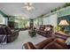 Spacious living room with large windows, a ceiling fan and comfortable leather furnishings at 7692 Sw 117Th Street Rd, Ocala, FL 34476
