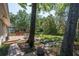 Outdoor living space with a wood deck, brick patio, and mature trees providing shade at 8120 Nw 48Th Ln, Ocala, FL 34482