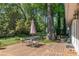 Charming backyard deck with dining set surrounded by mature trees and greenery at 8120 Nw 48Th Ln, Ocala, FL 34482