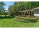 Lush backyard featuring a wooden pergola and well-maintained green lawn at 8120 Nw 48Th Ln, Ocala, FL 34482