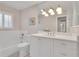 Elegant bathroom featuring white vanity, tile backsplash, and shower-tub combo at 8120 Nw 48Th Ln, Ocala, FL 34482
