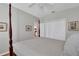 Spacious bedroom featuring a cozy bed, closet doors, and views into the kitchen and bathroom at 8120 Nw 48Th Ln, Ocala, FL 34482