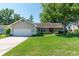 Traditional single-story home featuring an attached two-car garage, landscaped yard, and mature trees at 8120 Nw 48Th Ln, Ocala, FL 34482