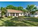 Grassy backyard featuring a screen enclosed lanai and a beautiful view of the lush, green landscaping and blue skies at 9101 Sw 91St Cir, Ocala, FL 34481