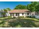 Rear view of the property showcasing the screened lanai, lush lawn and landscaping, and lovely, clear blue skies at 9101 Sw 91St Cir, Ocala, FL 34481