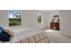 Bedroom with wood floors, two windows, and a wood dresser at 9101 Sw 91St Cir, Ocala, FL 34481