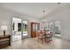 Open dining area with hardwood floors, a modern chandelier and french door to outdoor patio at 9101 Sw 91St Cir, Ocala, FL 34481