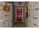 The front door is red with a decorative wreath on the wall at 9101 Sw 91St Cir, Ocala, FL 34481