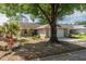 Charming front exterior with brick facade, mature landscaping, a large shade tree, and a driveway leading to the attached garage at 9101 Sw 91St Cir, Ocala, FL 34481