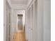 Hallway with wood floors, a closet, and access to the bathroom with a glass shower at 9101 Sw 91St Cir, Ocala, FL 34481