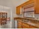 Kitchen sink with granite counters, wood cabinets and view to dining room at 9101 Sw 91St Cir, Ocala, FL 34481