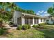 Back of house featuring a spacious screened lanai, a beautiful yard with lush landscaping, and a manicured lawn at 9101 Sw 91St Cir, Ocala, FL 34481