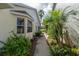 Lush side yard with tropical plants leading to the backyard at 9101 Sw 91St Cir, Ocala, FL 34481