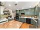 Stylish kitchen showcasing dark green cabinetry, stainless steel appliances, and a granite-topped island at 9153 Sw 83Rd Ter # E, Ocala, FL 34481