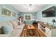 Bright living room featuring a comfortable sofa, large windows, and a wall-mounted television at 9153 Sw 83Rd Ter # E, Ocala, FL 34481