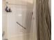 Bright white tiled shower with safety grab bar, modern shower head and decorative curtains at 9153 Sw 83Rd Ter # E, Ocala, FL 34481