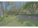 The backyard offers a private oasis with mature trees and lush green grass at 9325 Se 132Nd Pl, Summerfield, FL 34491
