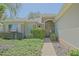 Charming front entrance featuring a decorative door, manicured shrubs, and a walkway at 9325 Se 132Nd Pl, Summerfield, FL 34491