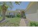 Inviting front entrance with a decorative door, lush landscaping, and a paved walkway at 9325 Se 132Nd Pl, Summerfield, FL 34491
