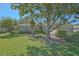 Well-manicured front yard featuring mature trees, shrubs, and a charming single-story home at 9325 Se 132Nd Pl, Summerfield, FL 34491