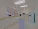 Bright kitchen features white cabinets, granite countertops, and an island with tile flooring at 9325 Se 132Nd Pl, Summerfield, FL 34491