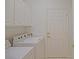 Clean laundry room features a washer, dryer and storage cabinets at 9325 Se 132Nd Pl, Summerfield, FL 34491