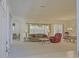 Bright and airy living room with neutral carpet, ceiling fan, and large windows at 9325 Se 132Nd Pl, Summerfield, FL 34491