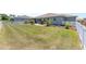 Wide shot of backyard featuring green grass, a white fence, and a patio area with outdoor seating at 9573 Sw 79Th Loop, Ocala, FL 34481