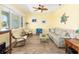 Cozy living room features wood floors, comfortable seating, and large windows at 9573 Sw 79Th Loop, Ocala, FL 34481