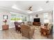 Bright living room featuring hardwood floors, tray ceiling, and large windows at 9573 Sw 79Th Loop, Ocala, FL 34481