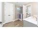 Bright bathroom features double doors, wood floors, modern sink, and walk-in shower at 9573 Sw 79Th Loop, Ocala, FL 34481