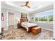 Cozy main bedroom with wood floors, tray ceiling, and large windows overlooking the backyard at 9573 Sw 79Th Loop, Ocala, FL 34481