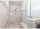 Walk-in shower features gray tiles, accent border, glass doors, and a built-in bench at 9573 Sw 79Th Loop, Ocala, FL 34481