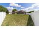 Spacious backyard with lush grass, a white fence, and views of the home at 9896 Sw 56Th Ct, Ocala, FL 34476