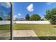 View of backyard with grass and white fence, from the house, on sunny day at 9896 Sw 56Th Ct, Ocala, FL 34476